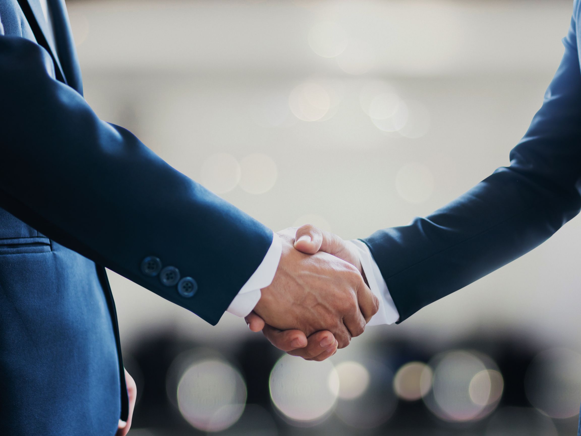 Close-up of two business professionals shaking hands, symbolizing a successful agreement or partnership.